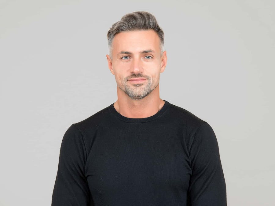 Man smiling agains a grey background