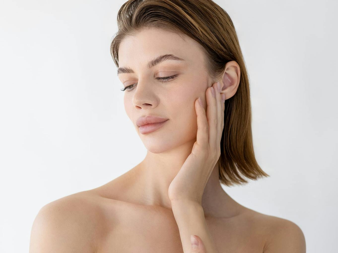 woman touching her cheek and looking down