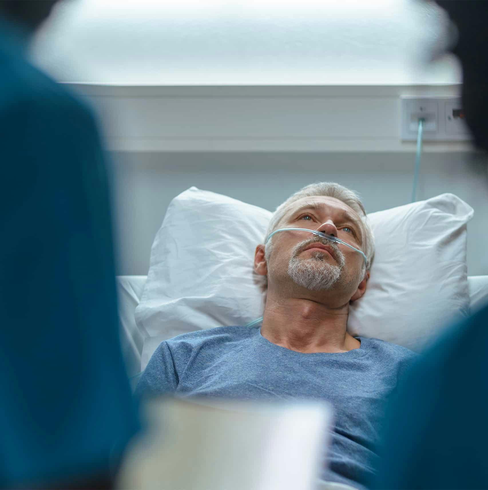 Man in a hospital bed in pain