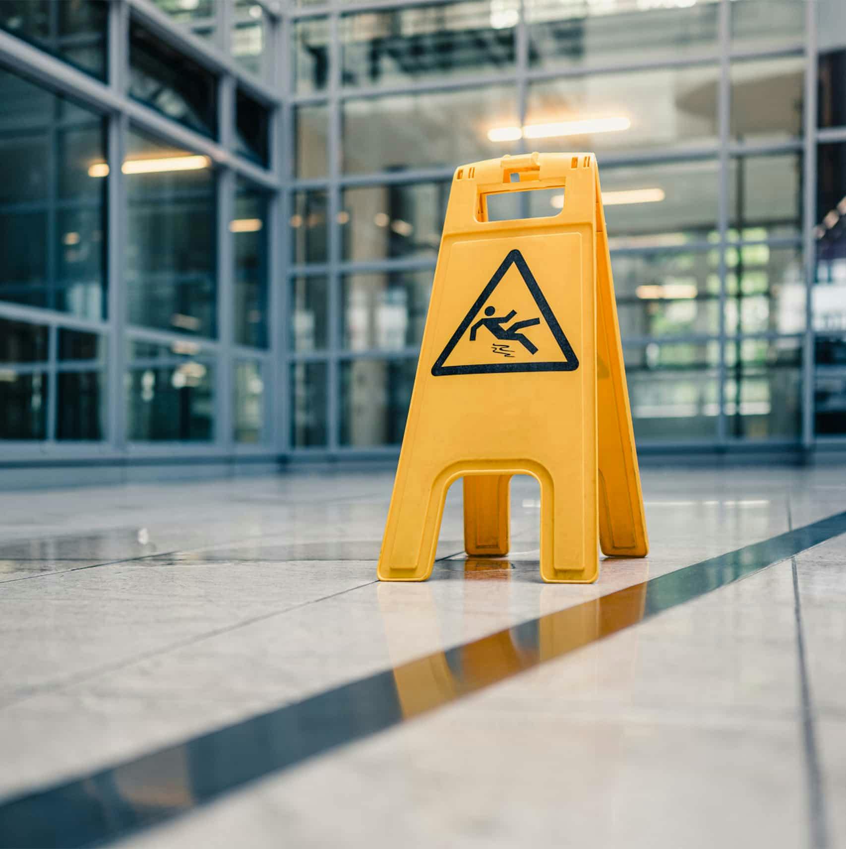 A wet floor sign near a puddle