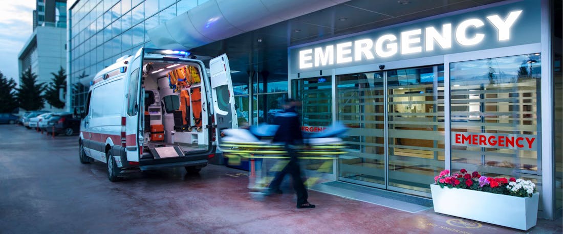 An ambulance and EMS rushing someone into the ER