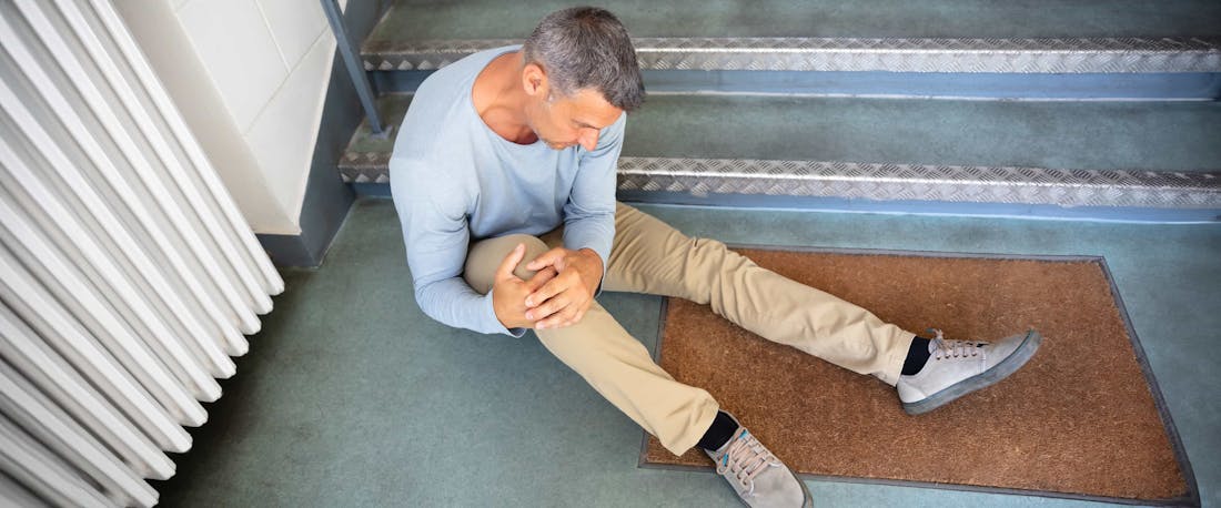 A man holding his knee after a fall