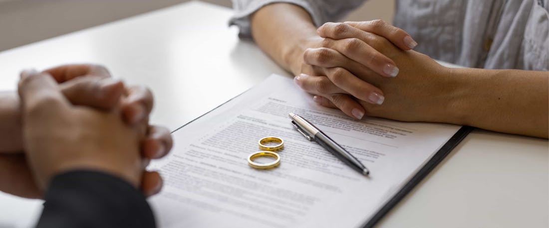 two wedding rings laying on a legal document