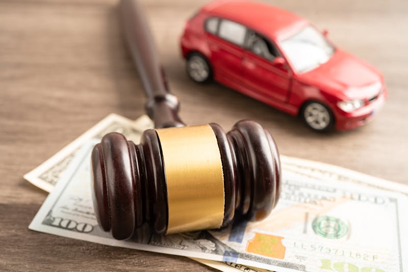 A car with a gavel and cash