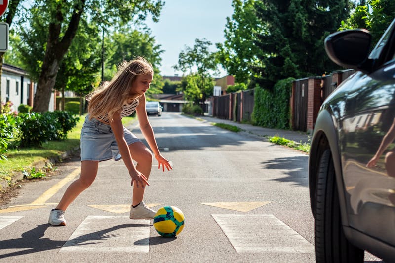 A child running into street after a ball