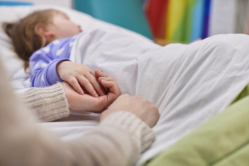A parent holding child's hand