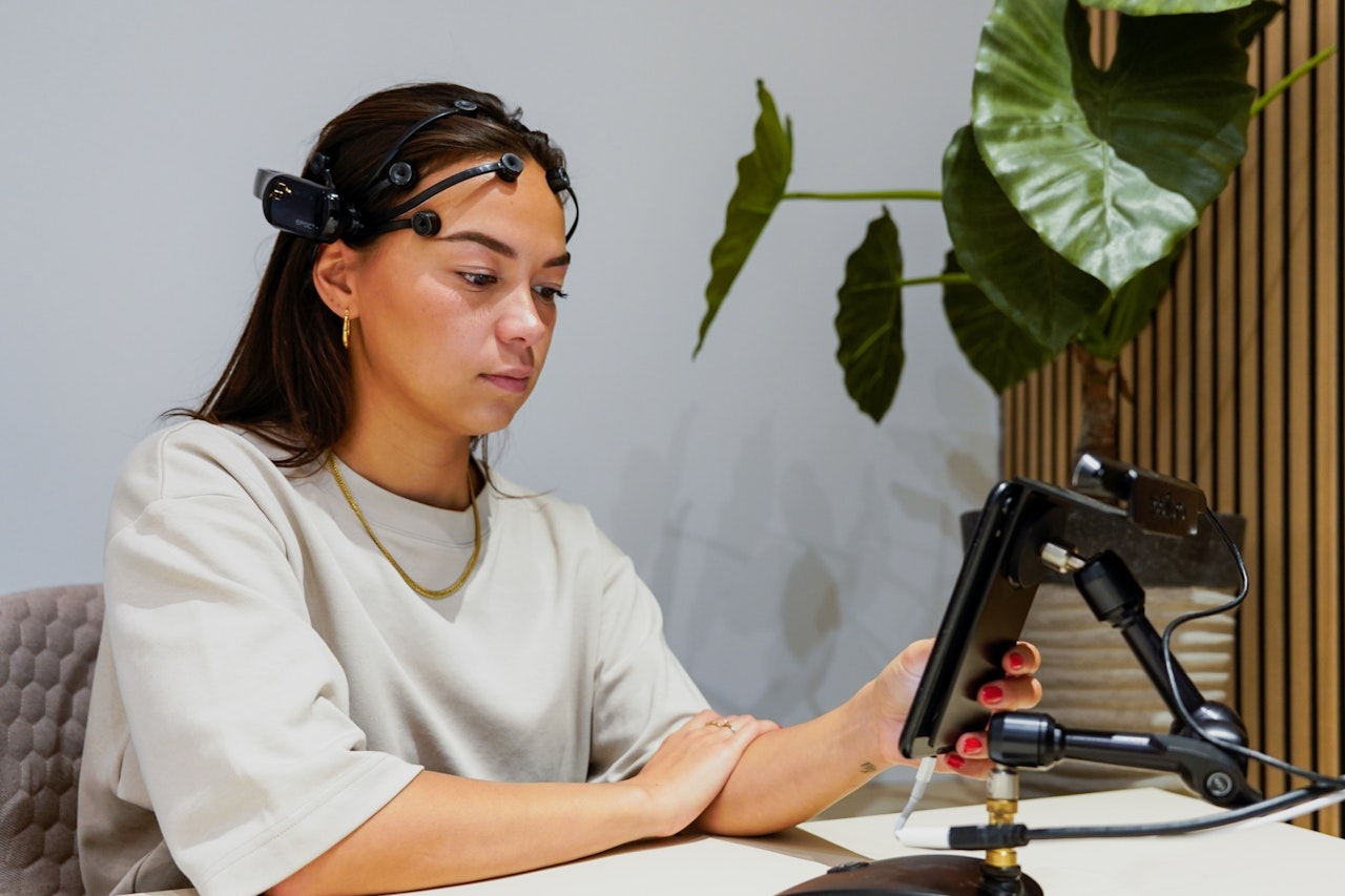 Respondent draagt een EEG-headset terwijl ze smartphone gebruikt