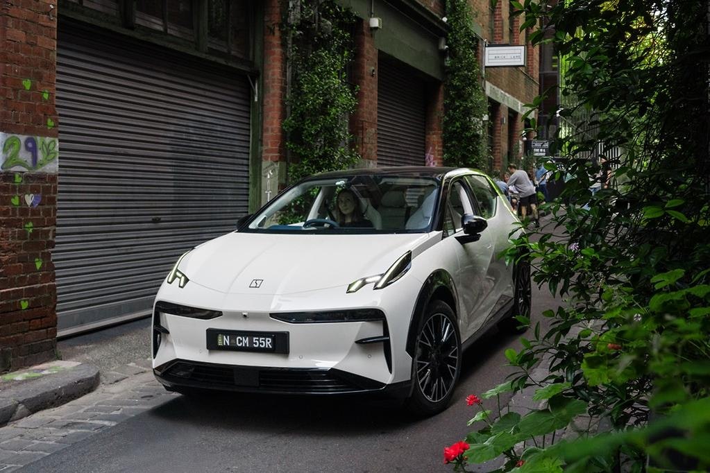 Zeekr X luxury electric SUV in Palace Beige in Melbourne Laneway with trees and flowers.