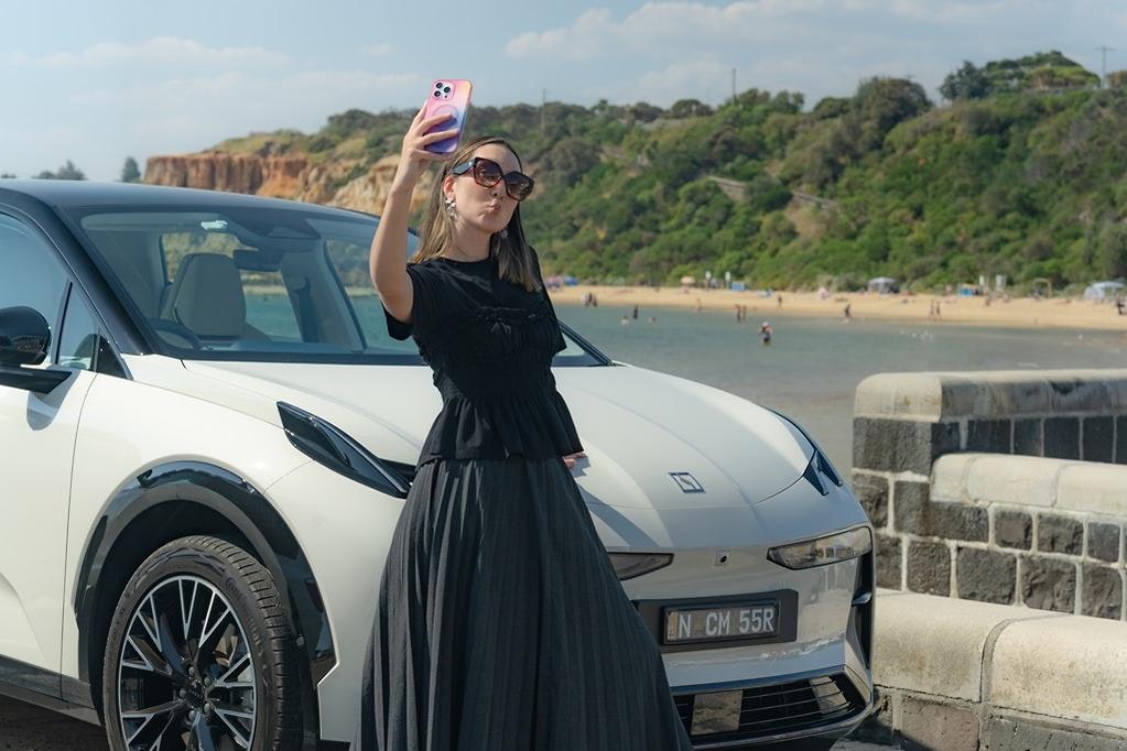 ZEEKR X Luxury Electric SUV in Palace Beige Front Shot with Andrea Hobbs taking Selfie.