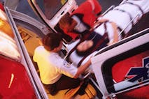 An EMT moves woman on gurney into an ambulance. Missouri