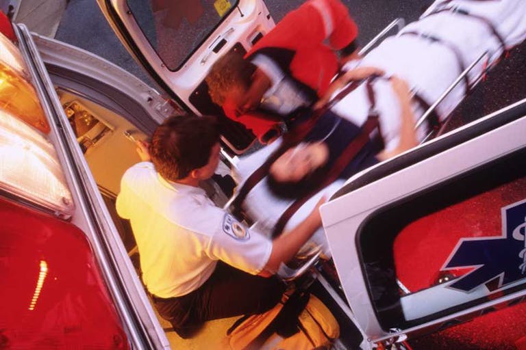 An EMT moves woman on gurney into an ambulance. Missouri