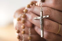 Photo: Getty Images person holding Catholic rosary in hands