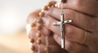 person holding Catholic rosary in hands