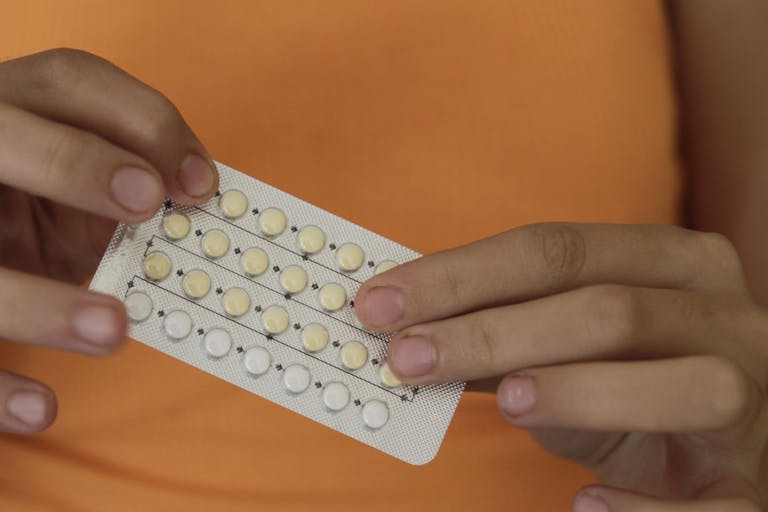 Woman’s hands holding birth control pills