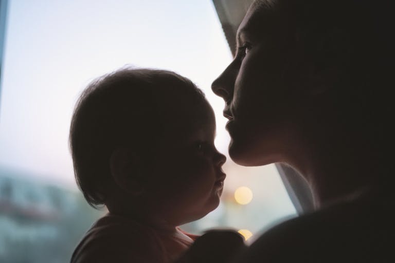 Silhouette of mother kissing daughter