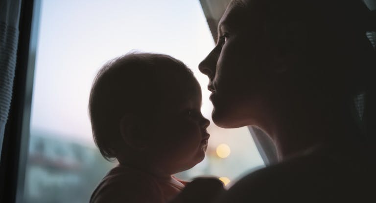 Silhouette of mother kissing daughter