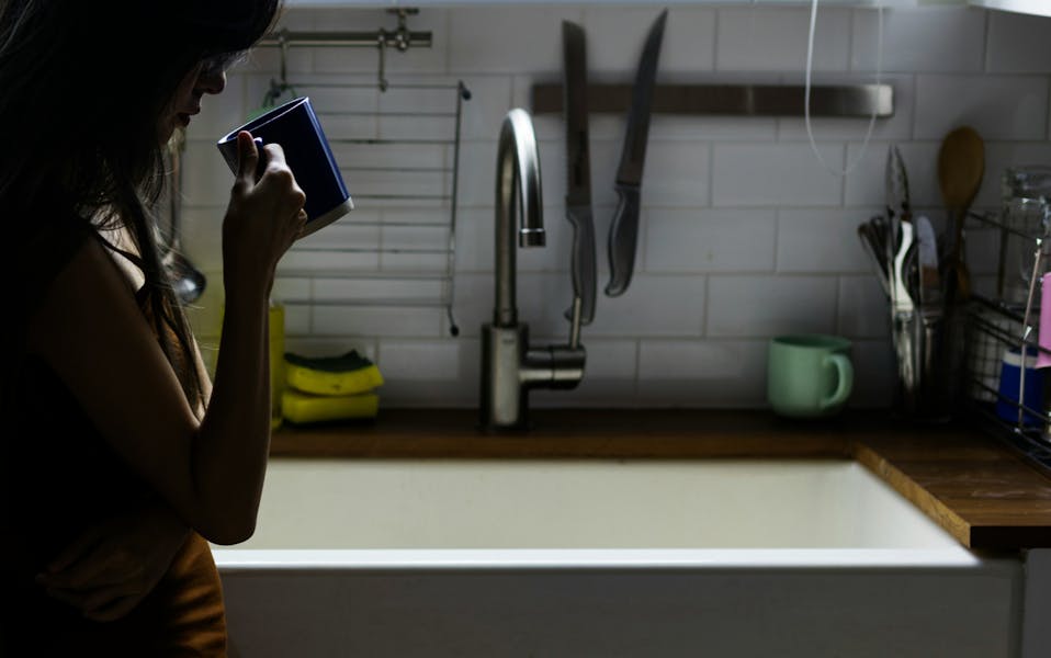 mother drinking coffee in kitchen