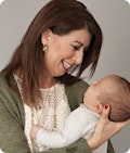 A woman smiling down at a baby