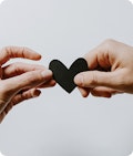 two hands holding a paper heart
