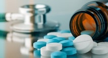 Blue and white pills are spilled near a stethoscope. assisted suicide, assisted death, euthanasia, euthanized