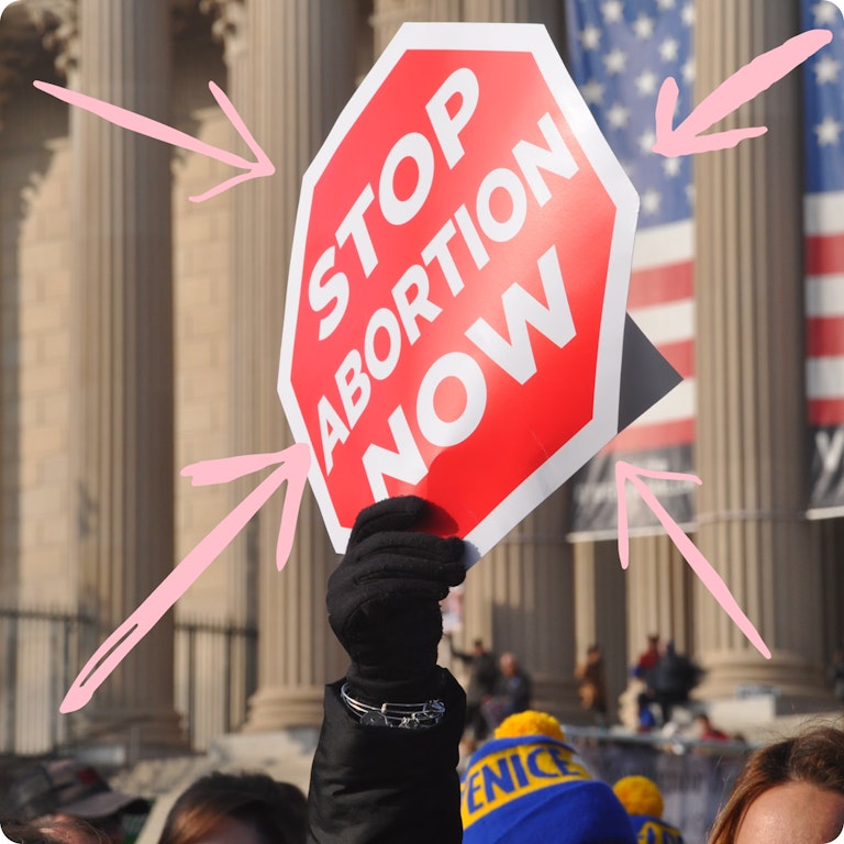 A red and white protest sign in front of the White House
