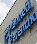 The planned parenthood sign on a gray building