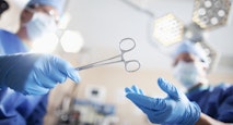 Low angle view of hands of doctor surgeon nurse passing medical equipment tool in surgery operating room hospital