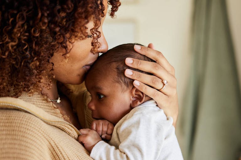 Mother kissing with her baby boy in her arms
