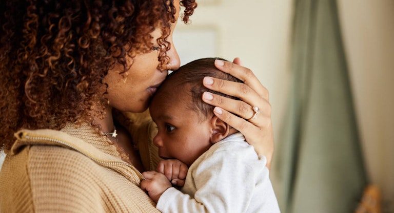 Mother kissing with her baby boy in her arms