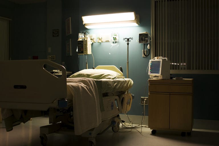 Bed in darkened empty hospital room