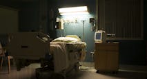 Bed in darkened empty hospital room