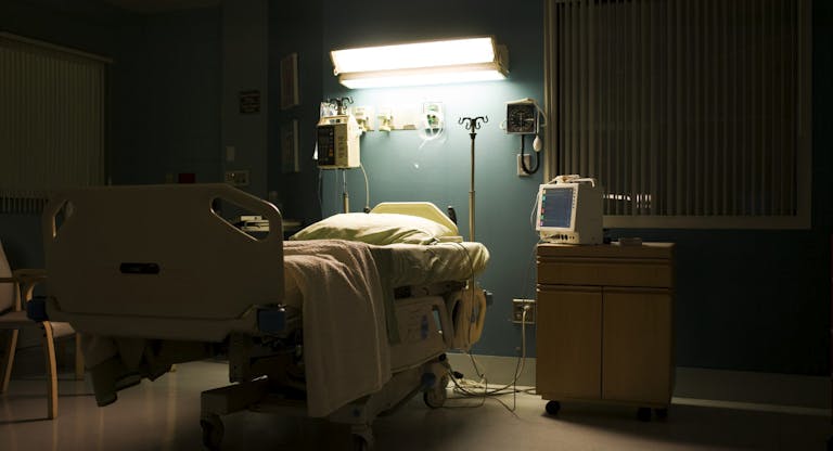 Bed in darkened empty hospital room