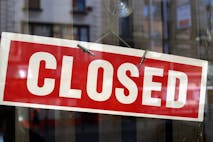 Photo: Getty Images image of red and white closed sign behind glass window