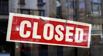 image of red and white closed sign behind glass window