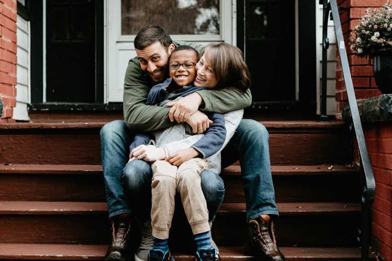 Multi racial family photos with adoptive son big hug
