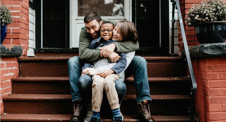 Multi racial family photos with adoptive son big hug