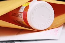 A close-up of a pill bottle in an envelope