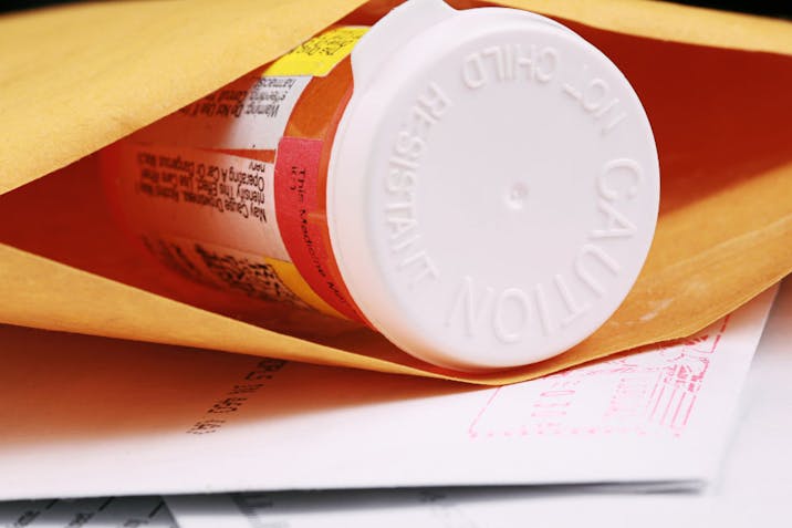 A close-up of a pill bottle in an envelope