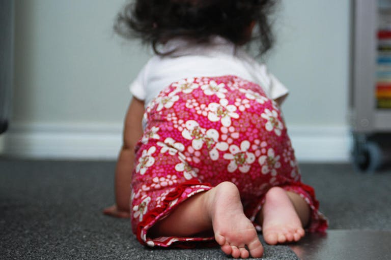 Baby girl crawling on floor