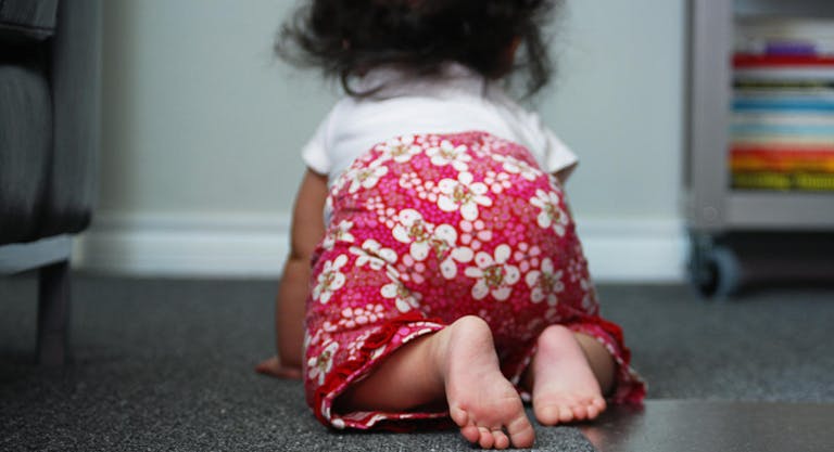 Baby girl crawling on floor