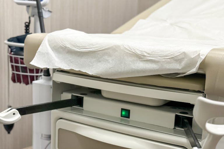 patient examination chair with medical stirrups in gynecologist office