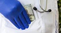 Doctor hides or lays down hundred dollar bill in pocket of white doctoral coat. Concept photo bribes, corruption in medicine, payment of medical care in private practice or public medicine, wages