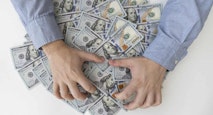 Man’s hands and a lot of dollar bills on a white table. Bribes, corrupt, cash. US dollars in male hands. The concept of profit, wages.