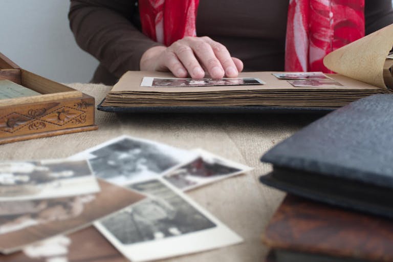 Midsection of woman holding old photo album