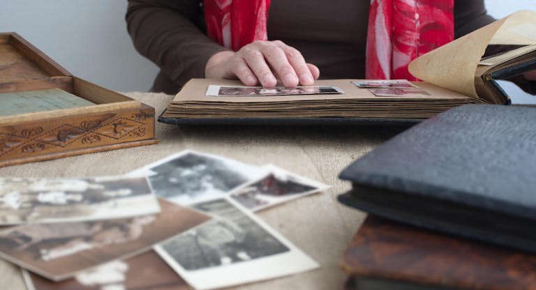 Midsection of woman holding old photo album