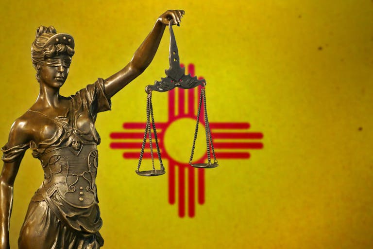 Lady Justice before a flag of New Mexico