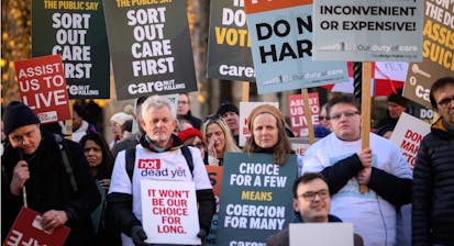 LONDON, ENGLAND - NOVEMBER 29: Supporters of the "Not Dead Yet" campaign, which opposes the Assisted Dying Bill, react outside the Houses of Parliament as news breaks that the Bill has passed the first stage, on November 29, 2024 in London, England. Today Members of Parliament are debating and voting on the second reading of the Terminally Ill Adults (End of Life) Bill, also referred to as the Assisted Dying Bill, which would give adults in England and Wales the right to choose to end their lives. The landmark private member's bill, proposed by backbench Labour MP Kim Leadbeater, would allow terminally ill people - who meet a set of safeguarding criteria - to seek medical assistance to die at a time of their choosing. (Photo by Leon Neal/Getty Images)