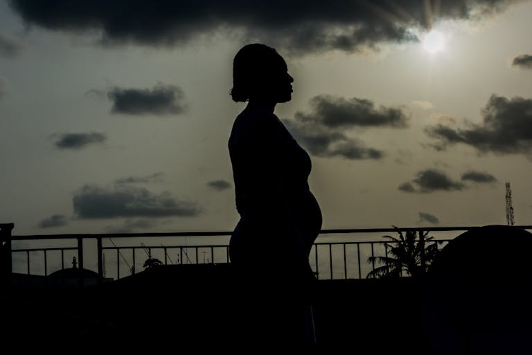 Silhouette Pregnant Woman Standing Against Sky During Sunset