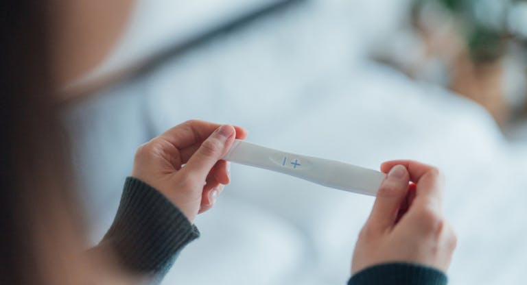 Rear View Cropped Shot Of Unrecognisable Woman Taking Pregnancy Test At Home