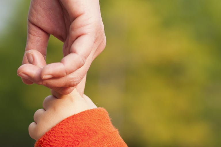Child holding mothers hand